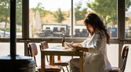Woman working with a digital tablet while sitting in a cafe. Technology and business concept.の写真素材