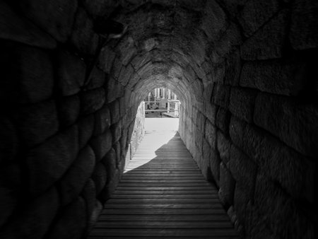 Black and white photo of an entrance to the Roman Amphitheater of Merida, in Spain. Tourism concept.