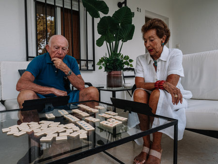 Marriage octogenarian play animatedly to a board game consisting of making combinations of numbers.の写真素材