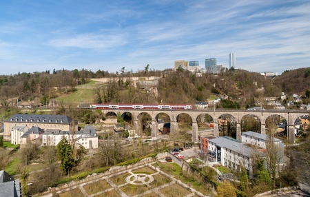 Train on viaduct in Luxembourg against background of European organisations buildingsのeditorial素材