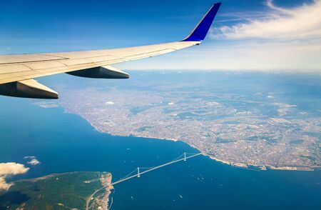 Flying above Japan: view of the Akashi Kaikyo Bridge through an airplane windowの写真素材