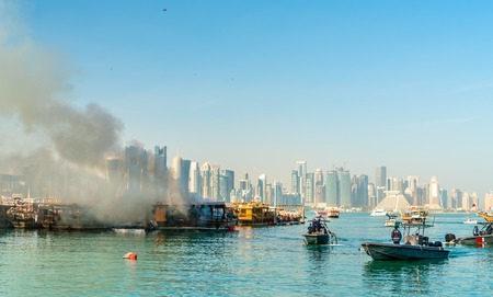Traditional arabic dhow on fire in Doha, Qatar