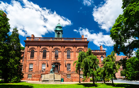 Old Albany Academy Building in Albany, United States, shows red sandstone walls, arched windows and a green cupola rising behind the Joseph Henry statue on a clear summer dayの写真素材
