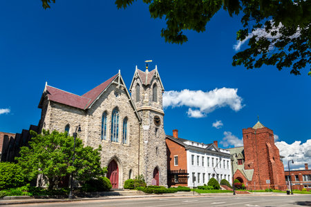 Price Memorial AME Zion Church neighbors St. Stephens Episcopal Church in Pittsfield, Massachusetts, United States, stone and brick facades glowing beneath a vivid blue summer skyの写真素材