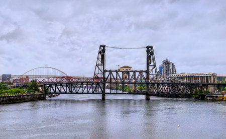 Double-deck vertical-lift Steel Bridge spans the Willamette River in Portland, Oregon, United States, and carries road, rail, pedestrian, and light rail trafficの写真素材