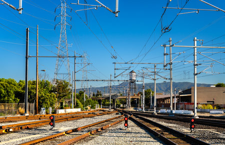 Central intermodal San Jose Diridon rail station in California, United States, serving Caltrain, Amtrak, Altamont Corridor Express, and VTA light rail, with multiple tracks, overhead catenary lines, and adjacent platforms under a clear daytime skyの写真素材