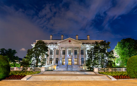 The American Red Cross National Headquarters in Washington, D.C., USA. This historic neoclassical landmark is illuminated against a dramatic night skyの写真素材