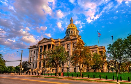 Colorado State Capitol building in Denver lit by golden hour sunset. The gold dome shines under a dramatic blue and pink cloudy skyの写真素材