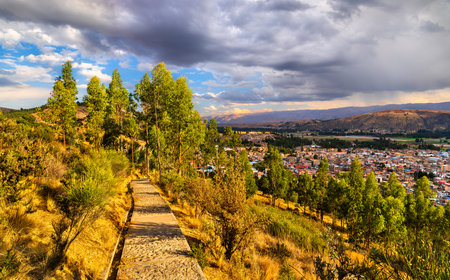 Stone trail leading to the Virgin of the Immaculate Conception statue in Concepcion, Peru. Eucalyptus trees line the path overlooking the town and Andes mountainsの写真素材