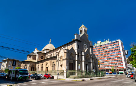 St. James Cathedral in Valparaiso, Chile. The historic Gothic Revival stone church stands on a street corner near Avenida Argentina under a clear blue skyの写真素材