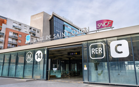 Saint-Ouen-sur-Seine, France - November 12, 2025: Entrance of the Saint-Ouen station serving Metro Line 14 and RER Line C. The modern glass facade features SNCF and transport signageのeditorial素材