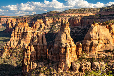 Scenic view of Colorado National Monument from Book Cliffs View. Red rock spires, including Independence Monument, fill the canyon under a blue skyの写真素材