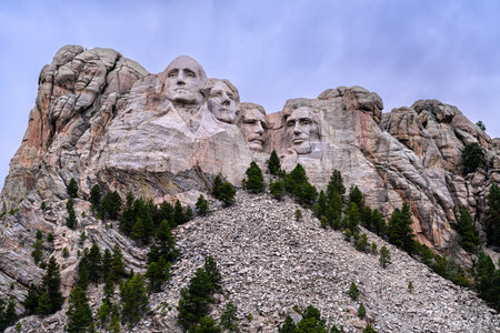 Mount Rushmore National Memorial features carved presidents faces in granite. Iconic sculpture stands above pine forest and talus slope in Black Hills of South Dakota, USAの写真素材