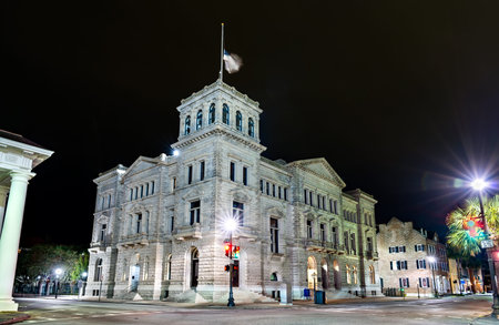 U.S. Post Office and Courthouse in Charleston, South Carolina. Historic Renaissance Revival federal building features a granite facade and corner tower illuminated at nightの写真素材