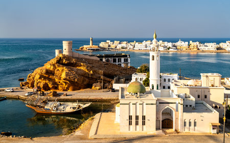 Scenic view of the historic Al Ayjah Watchtowers and a white mosque overlooking the bay with...