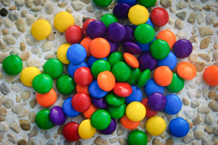 small bright colored candies on stones .