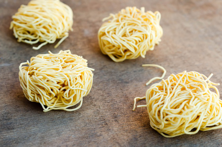 Fresh pasta nests on wooden table.の写真素材