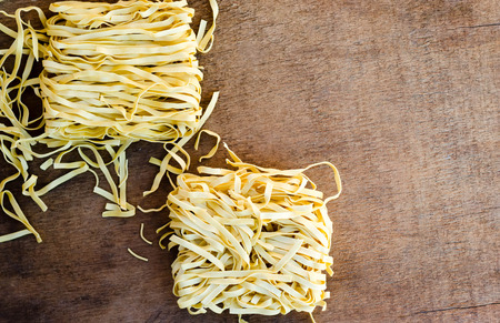 Fresh pasta nests on wooden table.の写真素材