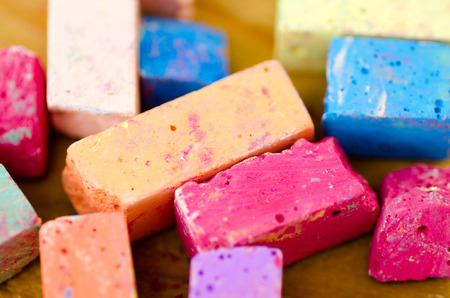 Bright pieces of chalk on wooden background.の写真素材