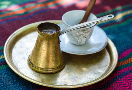 Strong and hot turkish coffee in traditional metal pot.