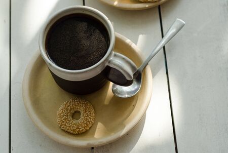 Hot sweet coffee with cinnamon powder in clay cup.の写真素材