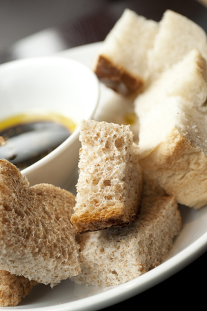 Balsamic Vinegar and Olive Oil in a bowl with a mix of white and wholemeal crusty bread in a cafe settingの写真素材