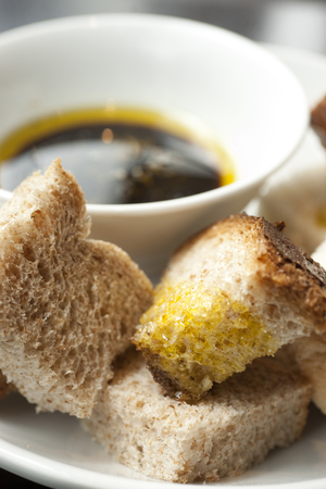 Balsamic Vinegar and Olive Oil in a bowl with a mix of white and wholemeal crusty bread in a cafe settingの写真素材