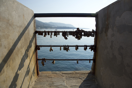 Love and Eternity padlocks fixed on to the end of the railings at Cefalu Harbour, Sicily, Italy - June 2015のeditorial素材