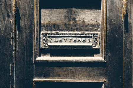 Old italian letter box on a vintage rustic wooden doorの写真素材