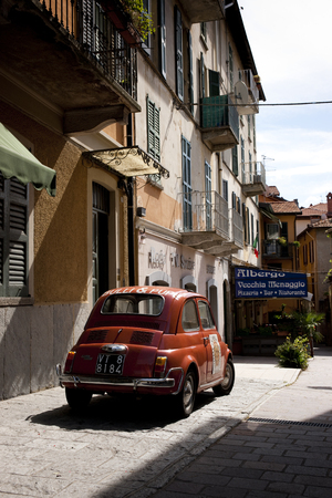 A classic red Fiat 500 car parked in a traditional Italian street near Lake Como, Lombardy, Italy - 29th August 2011のeditorial素材