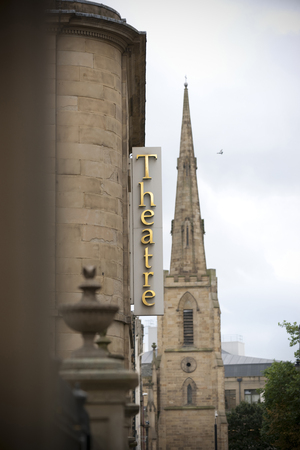 Huddersfield, West Yorkshire, UK, October 2013, a view of the sign for the lawrence batley theatre with St Paul's Concert Hall spireのeditorial素材