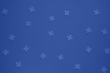 Flat blank wooden puzzles on blue background view from above. Festive background for a...