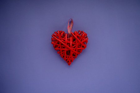 Valentine's Day background with heart. Red wicker, wooden heart in the center of the banner. Very Peri background color 2022. Flat lay, copy space. The concept of love, happy family, wedding, fidelity.の写真素材