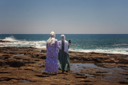 Young Turkish women, tourist travelers makes a selfie on a mobile phone against the background of the sea. lifestyle. Stream blogger, influencer, travel blogger. selective focus. selective focus.の写真素材