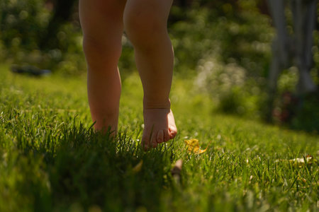 Bare feet of a child running on the grass. healthy lifestyle conceptの写真素材