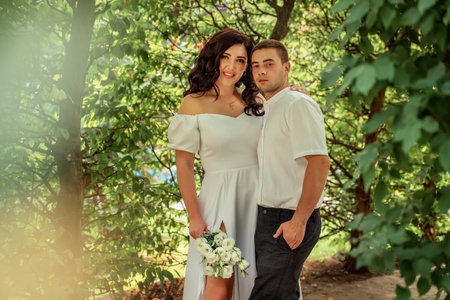 Couple in love summer forest against backdrop of dense greenery on Valentine's Day. view from bushes. Couple in love in white robes. Selective focus, blurred background, bokehの写真素材