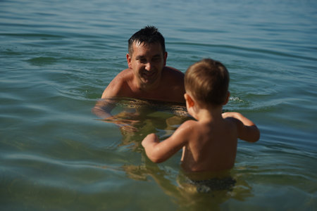 Father and son playing in water.の写真素材
