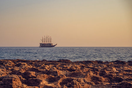 Tourist excursion ship sails in the Mediterranean Sea, view from the shore. Vacation, travel and tourism concept by ship. Blurred background, copy space.の写真素材