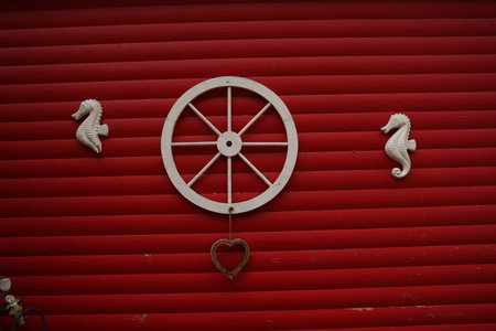 Decorative rural wooden wheel in wooden background. Old horse-drawn carriage made of wood attached to the wall of wooden log house.の写真素材