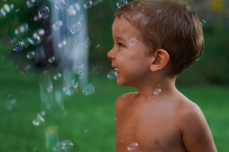 Little baby playing with colorful soap bubbles. A fun holiday with balls and bubblesの写真素材