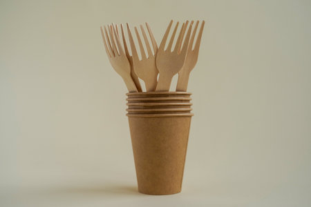 Paper cups with wooden forks on a white background. Recyclable garbage. Environmentally friendly conceptの写真素材