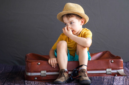 A child in summer clothes on a suitcase. A little fidget is preparing for a summer trip. dream babyの写真素材