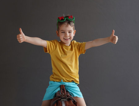 A child in summer clothes on a suitcase. A little fidget is preparing for a summer trip. dream babyの写真素材