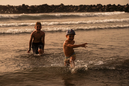 Children have fun on the seashore, splashes in all directions. Happy Summer Holiday. A fun holiday. Family Sea Vacationの写真素材