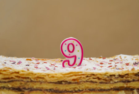 Birthday layer cake with candle number 9 nine close-up. birthday cake or anniversary