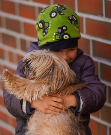Little boy lovingly hugging his dog. Focus on the dogの写真素材