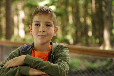 Close-up portrait of a cute boy on a green blurred backgroundの写真素材