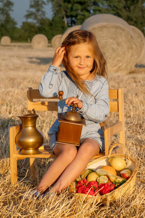 Cute girl sitting at a picnic. Family summer fun in the country. Summer holidaysの写真素材
