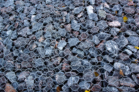 Photo gray gravel pebbles under a metal mesh.の写真素材