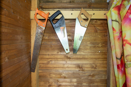 Garden tools old saws hanging the wooden wallの写真素材